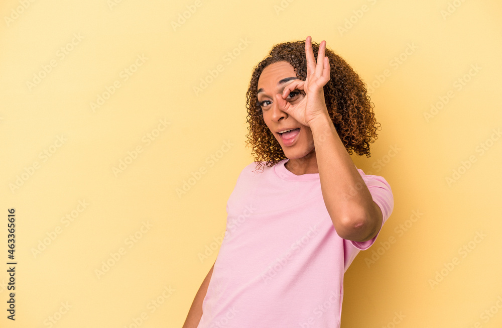 Young latin transsexual woman isolated on yellow background excited keeping ok gesture on eye. Young latin transsexual woman isolated on yellow background excited keeping ok gesture on eye.