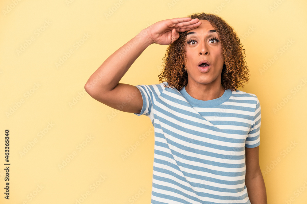 Young latin transsexual woman isolated on yellow background looking far away keeping hand on forehead. Young latin transsexual woman isolated on yellow background looking far away keeping hand on forehead.