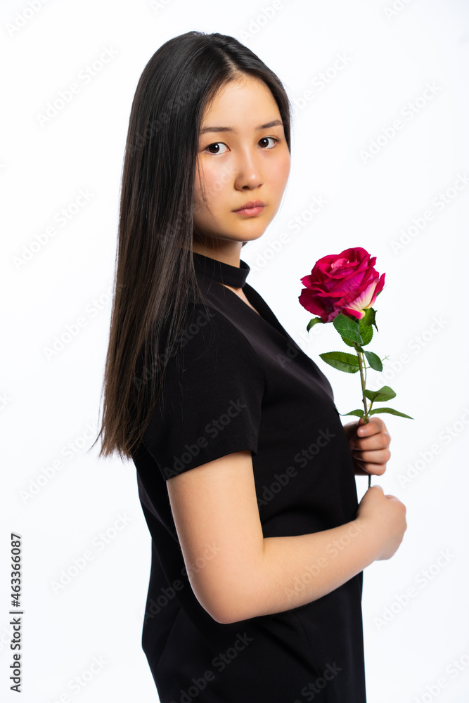 portrait of a girl in a black dress with long black hair on a white background. Oriental beauty with red rose portrait of a girl in a black dress with long black hair on a white background. Oriental beauty with red rose