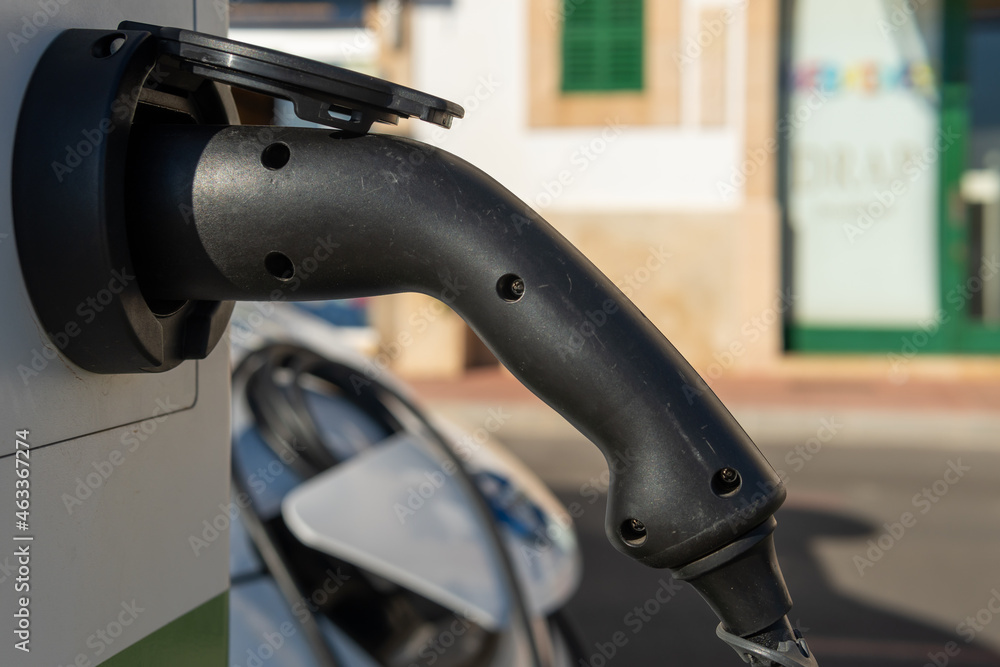 Close-up of an electric car charging its battery at a charging point located in the seaport of the town of Portocolom, island of Mallorca, Spain
