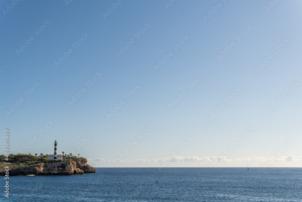 General view of the lighthouse of the Majorcan town of Portocolom, at dawn on a sunny day. Maritime navigation image