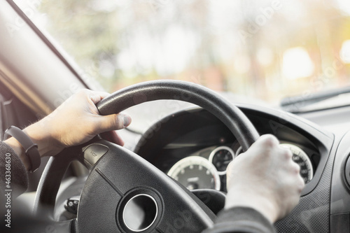 Man holding steering wheel and driving his car with highlights