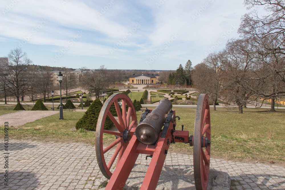 View from a hill on a cannon of the Uppsala Castle Bastion and The Uppsala Botanical Garden University building, Sweden.
