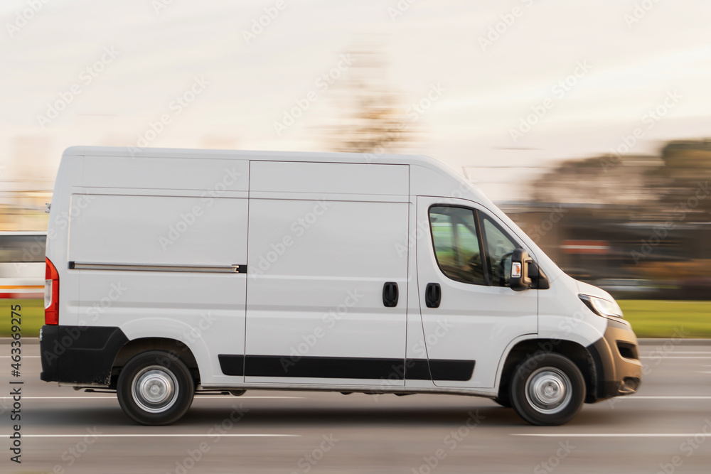 A white truck is driving down the street. Small commercial freight transport in the city. Motion blur A white truck is driving down the street. Small commercial freight transport in the city. Motion blur