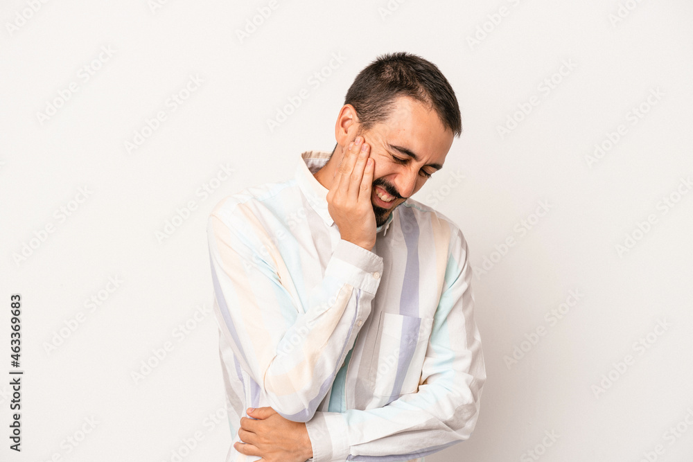 Young caucasian man isolated on white background laughs happily and has fun keeping hands on stomach. Young caucasian man isolated on white background laughs happily and has fun keeping hands on stomach.