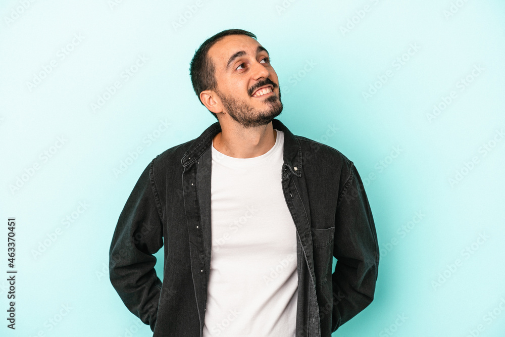 Young caucasian man isolated on blue background relaxed and happy laughing, neck stretched showing teeth. Young caucasian man isolated on blue background relaxed and happy laughing, neck stretched showing teeth.