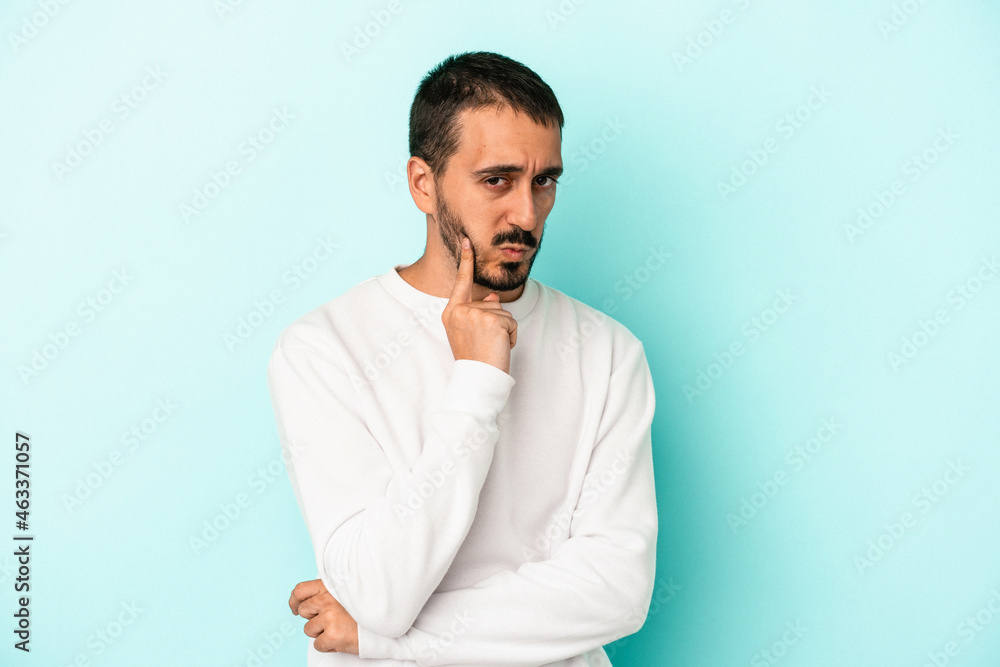 Young caucasian man isolated on blue background contemplating, planning a strategy, thinking about the way of a business. Young caucasian man isolated on blue background contemplating, planning a strategy, thinking about the way of a business.