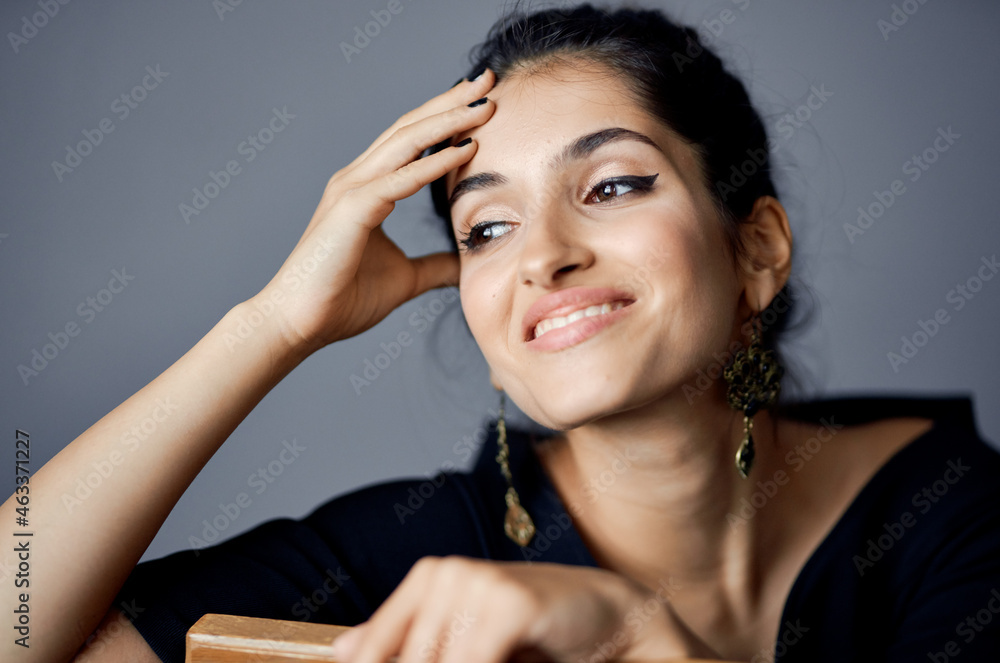 Obraz premium beautiful woman in a black dress near the chair luxury fashion dark background