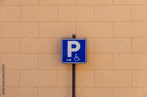 Blue sign indicating handicapped parking on a brick background