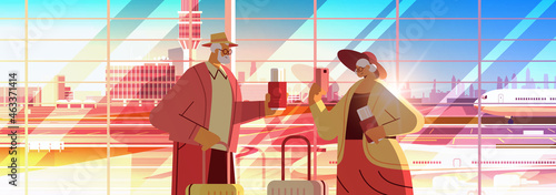 senior couple of tourists using smartphones grandparents with luggage passports and tickets ready to boarding