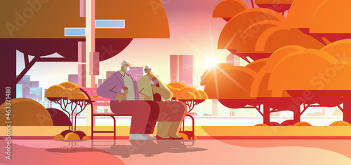 senior couple sitting on bench and eating ice cream happy grandparents spending time together in park