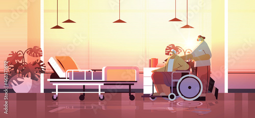 helper taking care of senior disabled patient nurse pushing wheelchair care service concept hospital ward interior