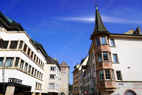 Facades of old houses with stone tower in the background at the old town of City of Schaffhausen. Photo taken September 25th, 2021, Schaffhausen, Switzerland.