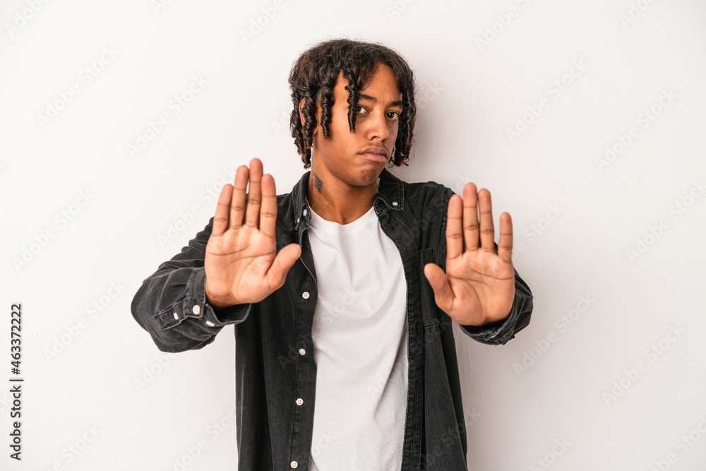 Naklejka premium Young african american man isolated on white background standing with outstretched hand showing stop sign, preventing you.