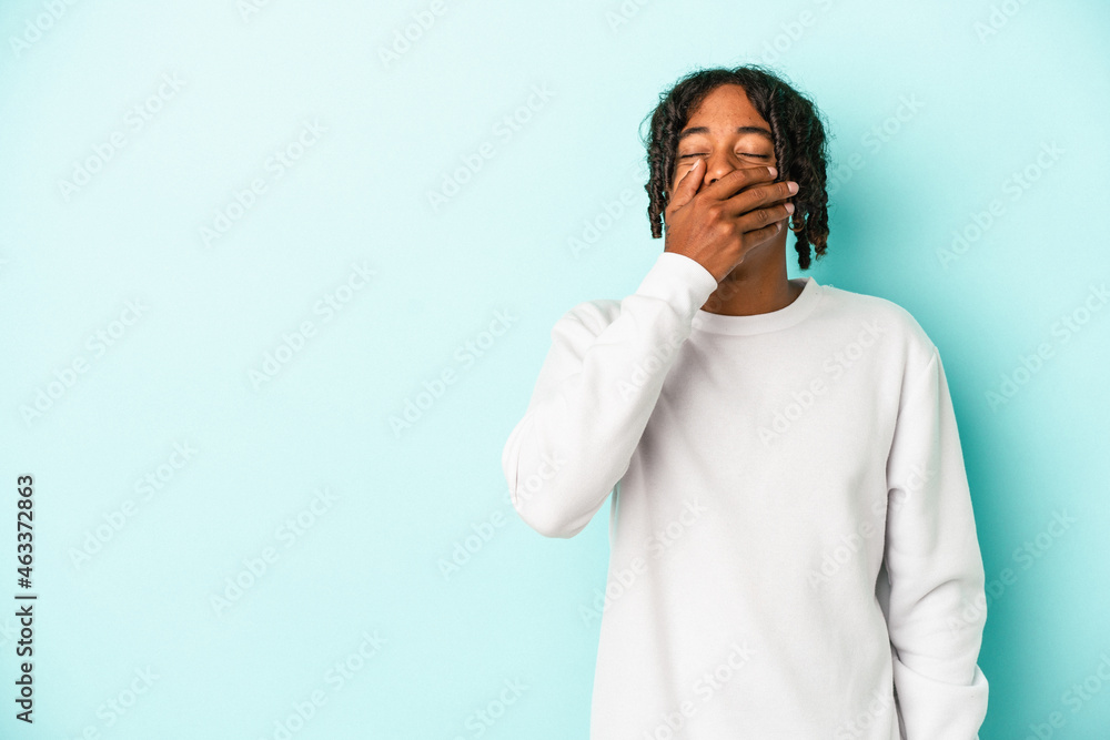 Young african american man isolated on blue background laughing happy, carefree, natural emotion. Young african american man isolated on blue background laughing happy, carefree, natural emotion.