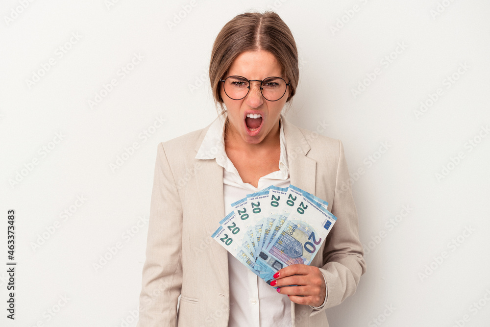 Young Russian business woman holding banknotes isolated on white background screaming very angry and aggressive. Young Russian business woman holding banknotes isolated on white background screaming very angry and aggressive.