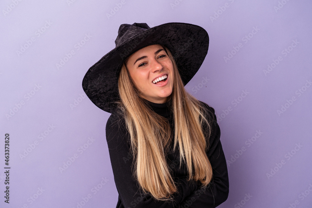 Young Russian woman disguised as a witch celebrating Halloween isolated on purple background laughing and having fun. Young Russian woman disguised as a witch celebrating Halloween isolated on purple background laughing and having fun.
