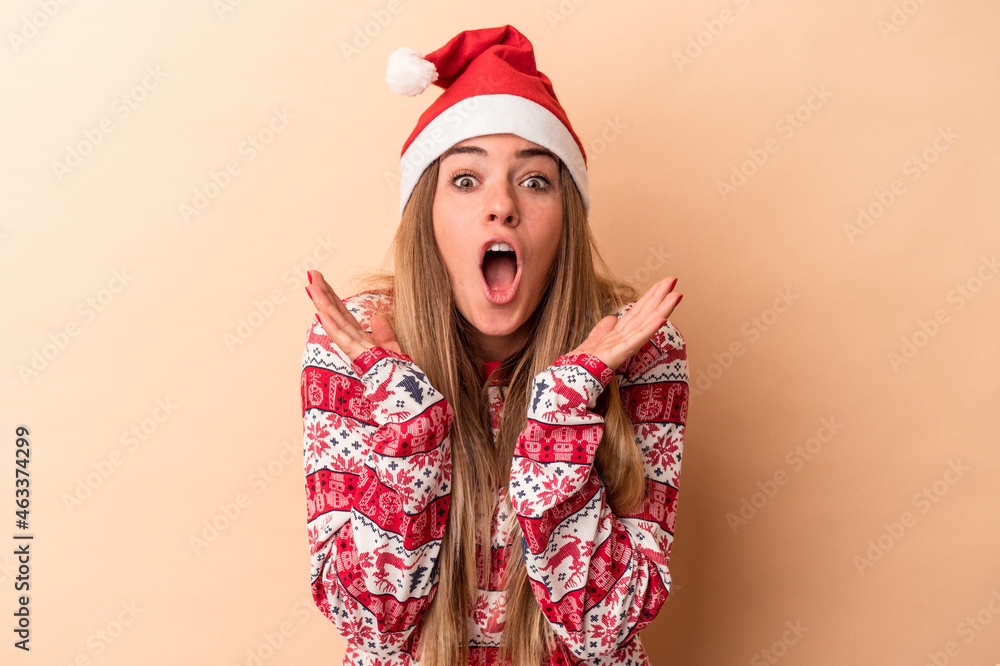 Young Russian woman celebrating Christmas isolated on beige background surprised and shocked.
