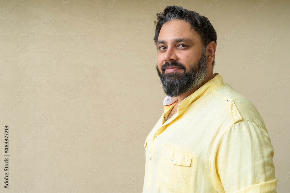 Portrait of handsome bearded Indian man against plain background Portrait of handsome bearded Indian man against plain background