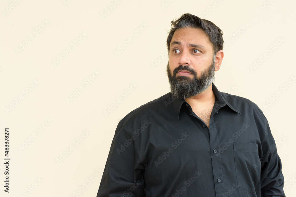 Portrait of handsome bearded Indian man against plain background Portrait of handsome bearded Indian man against plain background