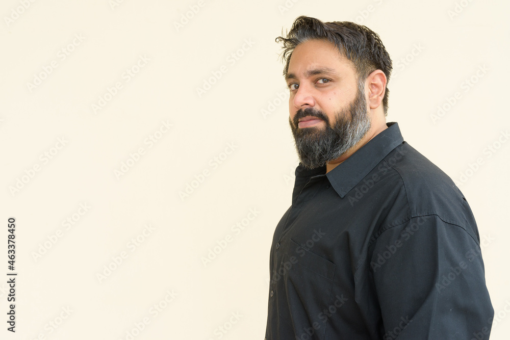Portrait of handsome bearded Indian man against plain background Portrait of handsome bearded Indian man against plain background