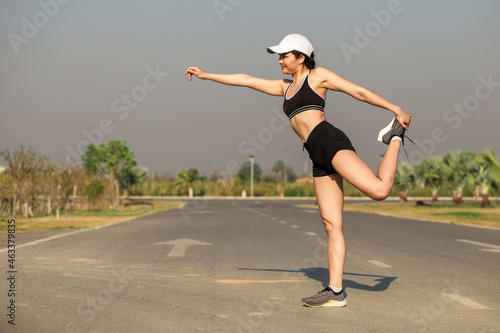 Healthy young Asian woman doing exercises in the morning happily in the park, outdoor © Pituk