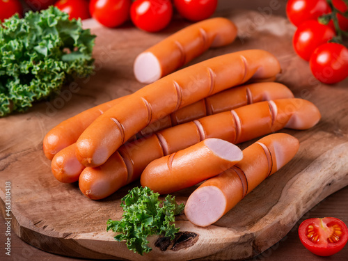 Fotografie, Obraz Styled Grilled Frankfurter sausages on wooden board with tomatoes and green herb
