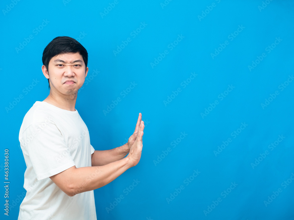 Asian man gesture push hand feeling heavy copy space blue background Asian man gesture push hand feeling heavy copy space blue background