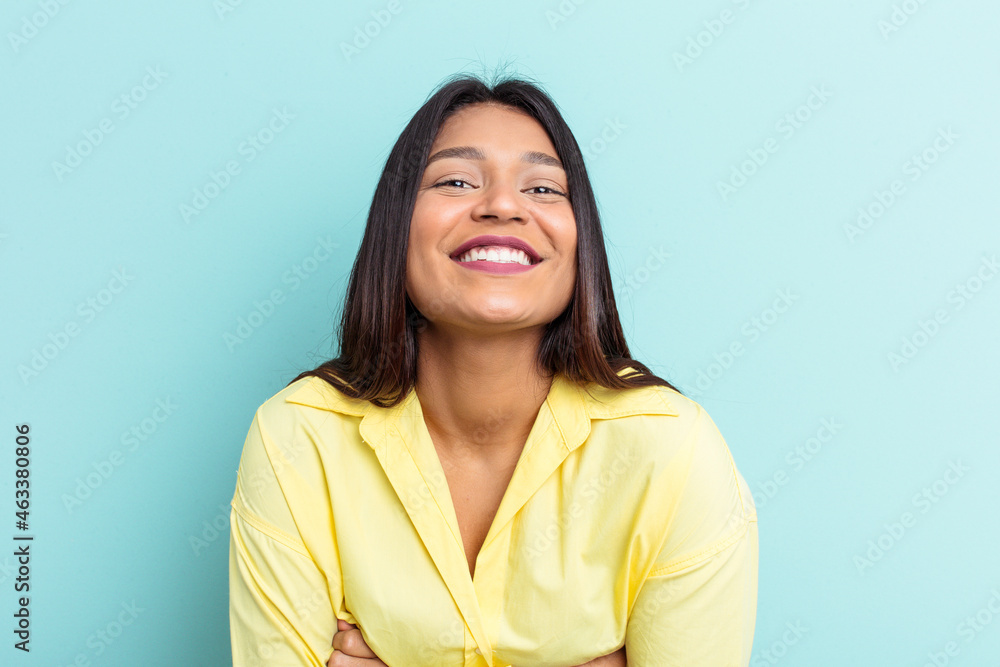 Fototapeta premium Young Venezuelan woman isolated on blue background laughing and having fun.