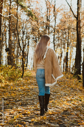  a blonde adult girl walks in the autumn forest. a walk in the fresh air alone
