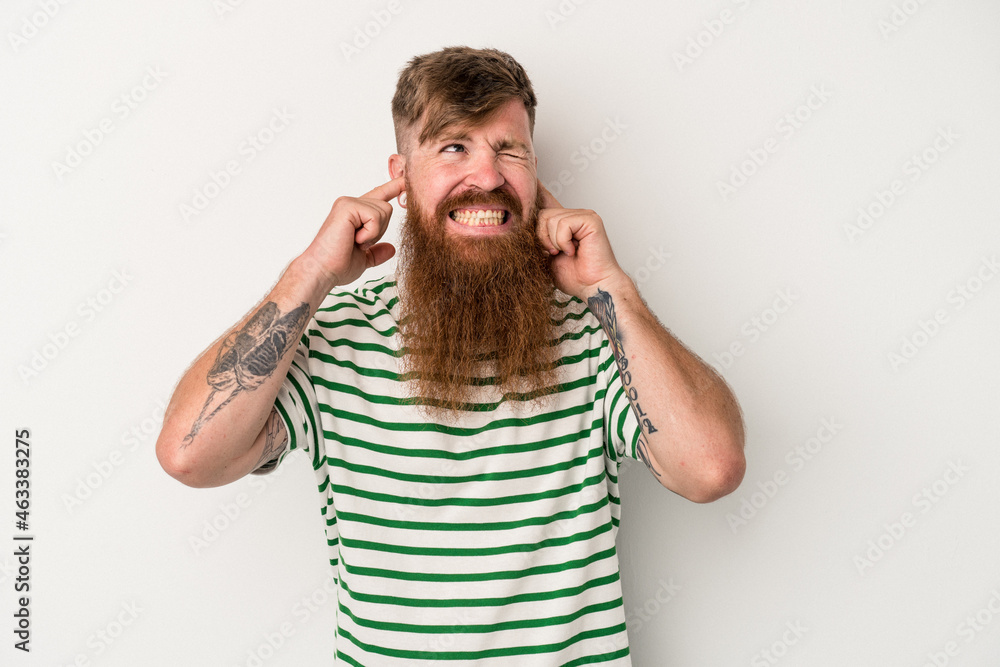 Young caucasian ginger man with long beard isolated on white background covering ears with fingers, stressed and desperate by a loudly ambient. Young caucasian ginger man with long beard isolated on white background covering ears with fingers, stressed and desperate by a loudly ambient.