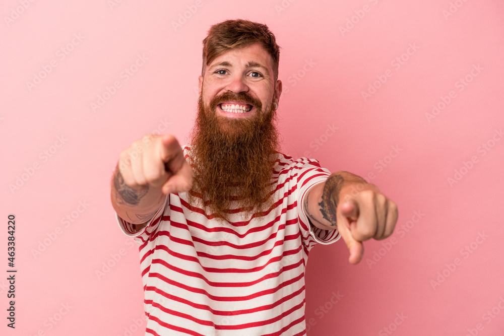 Young caucasian ginger man with long beard isolated on pink background cheerful smiles pointing to front. Young caucasian ginger man with long beard isolated on pink background cheerful smiles pointing to front.