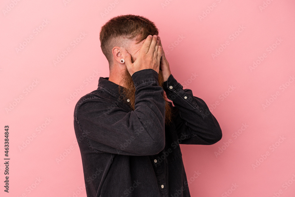 Young caucasian ginger man with long beard isolated on pink background afraid covering eyes with hands. Young caucasian ginger man with long beard isolated on pink background afraid covering eyes with hands.