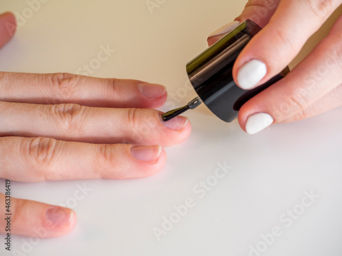 applying a colorless base to the nail. Manicure at home