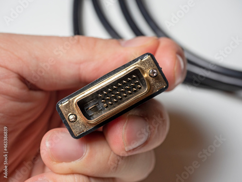 The DVI cable is black in the male hand. Cable for transmitting video images to digital display devices.
