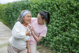asian young daughter caring for  sick senior mother To suffering chest pain or Heart attack at home . old mom suffering from illness has a adult caregiver woman  to take care