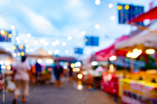 An abstract blur of an evening night market where people start shopping happily during COVID