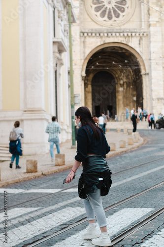 young girl crossing the street with a cathedral behind