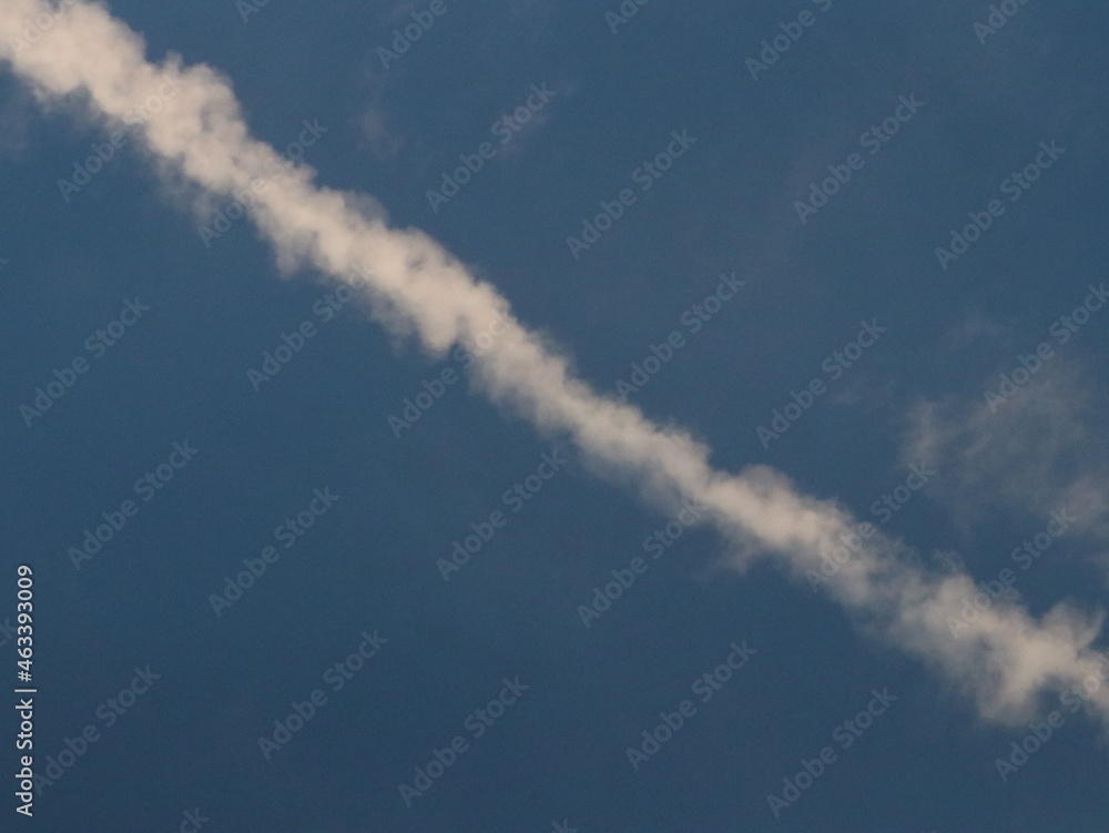 White trail from an airplane in the blue sky White trail from an airplane in the blue sky
