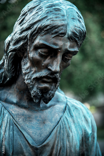 Obraz na płótnie A fragment of ancient figure of the sad Jesus Christ in the old cemetery as a symbol of love and salvation of mankind after death in the kingdom of eternity. w salonie