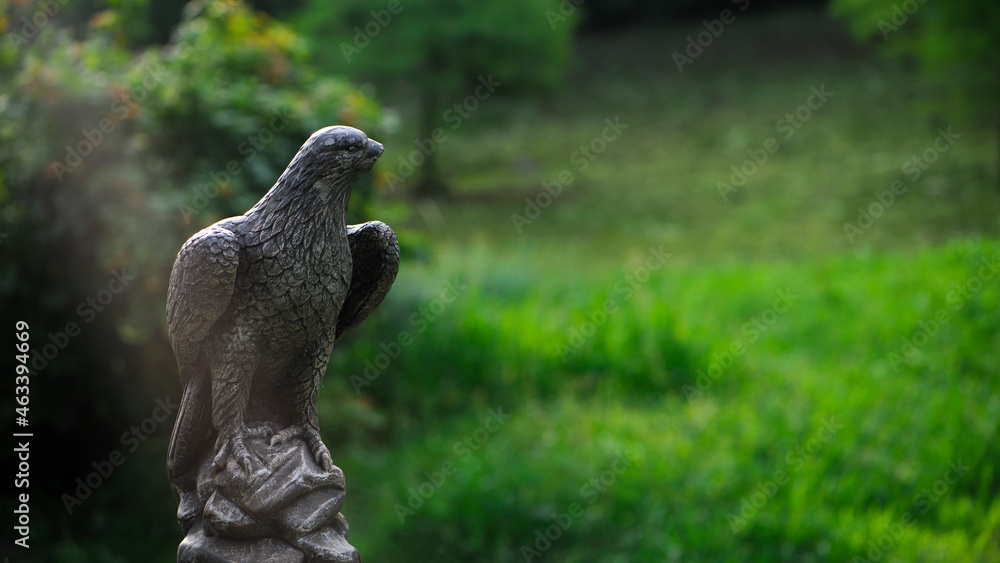 eagle sculpture in the park. plaster eagle, in the autumn city park. close-up, against a background of green grass, summer or autumn season eagle sculpture in the park. plaster eagle, in the autumn city park. close-up, against a background of green grass, summer or autumn season