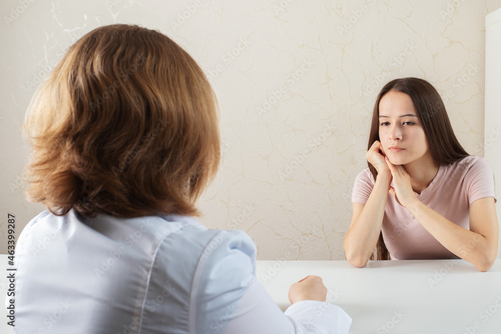 teenager and a psychologist at a consultation,doctor and a patient in a hospital in a medical office are talking teenager and a psychologist at a consultation,doctor and a patient in a hospital in a medical office are talking