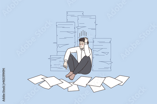 Unhappy male employee sit on floor near piles of paperwork worry about deadline. Upset stressed man worker surrounded by paper document. Overwork, fatigue concept. Vector illustration. 