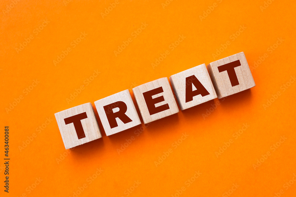 Obraz premium The hand puts a wooden cube with the letter T from the word TREND. The word is written on wooden cubes standing on the yellow surface of the table. Concept.