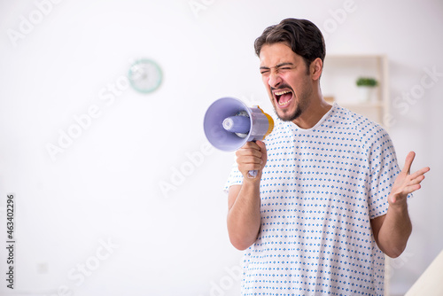 Young male patient holding megaphone