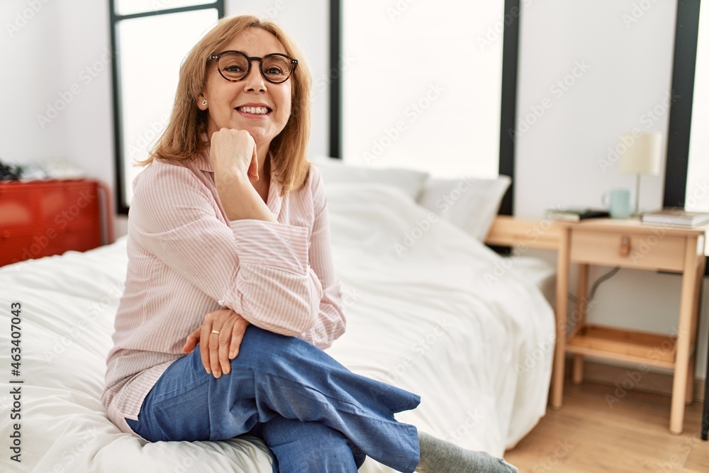Middle age blonde woman smiling happy relaxed sitting on the bed at home. Middle age blonde woman smiling happy relaxed sitting on the bed at home.