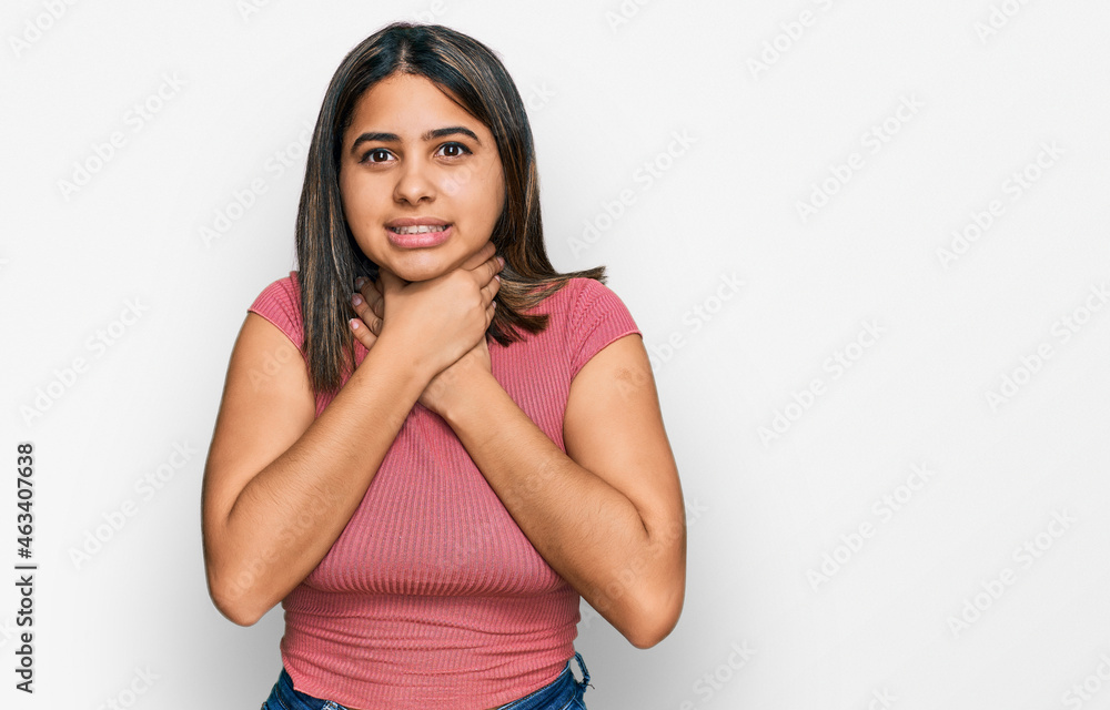 Young hispanic girl wearing casual t shirt shouting and suffocate because painful strangle. health problem. asphyxiate and suicide concept. Young hispanic girl wearing casual t shirt shouting and suffocate because painful strangle. health problem. asphyxiate and suicide concept.