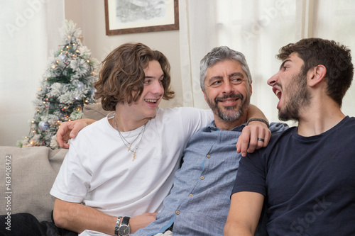 Père de famille s'amuse avec ses deux enfants adolescents pendant les fêtes de noël, moment de bonheur et de complicité photo