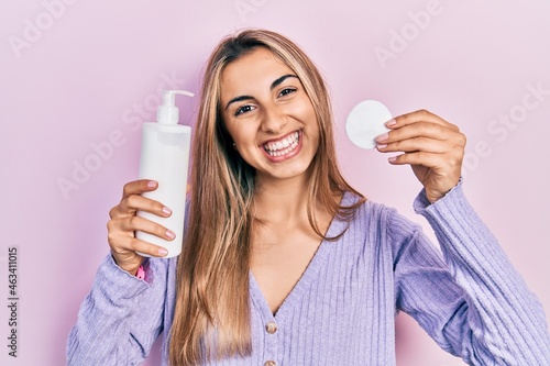 Beautiful hispanic woman holding cotton pad and make up remover smiling with a happy and cool smile on face. showing teeth.