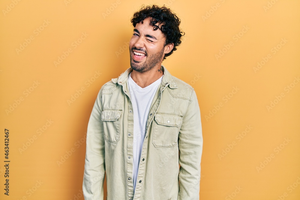 Young hispanic man wearing casual clothes winking looking at the camera with sexy expression, cheerful and happy face. Young hispanic man wearing casual clothes winking looking at the camera with sexy expression, cheerful and happy face.